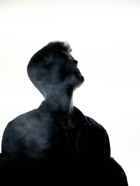 a person standing in front of smoke while on a cellphone