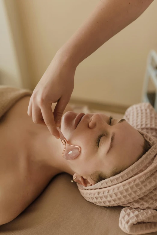 a woman is laying down while receiving a facial peel