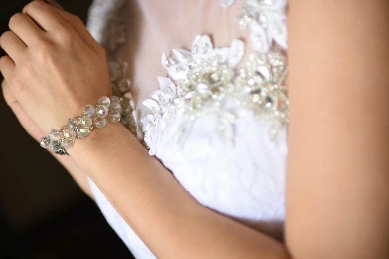 a close up view of a woman with a wedding dress and pearls celet