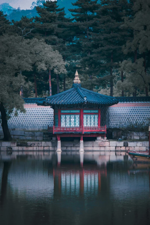 an asian pavilion at the end of a lake