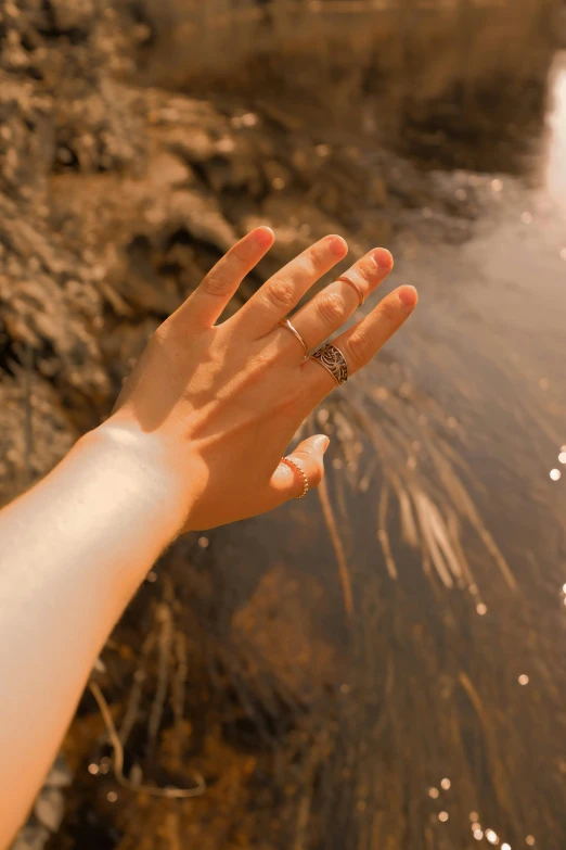 the hand is outstretched towards the river and water