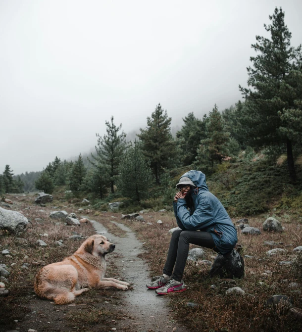 a man taking a break from hiking with his dog