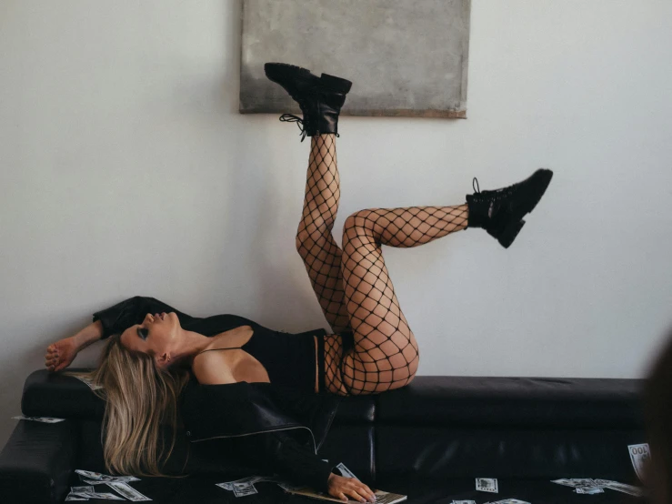 a woman with fishnet stockings lying on a couch