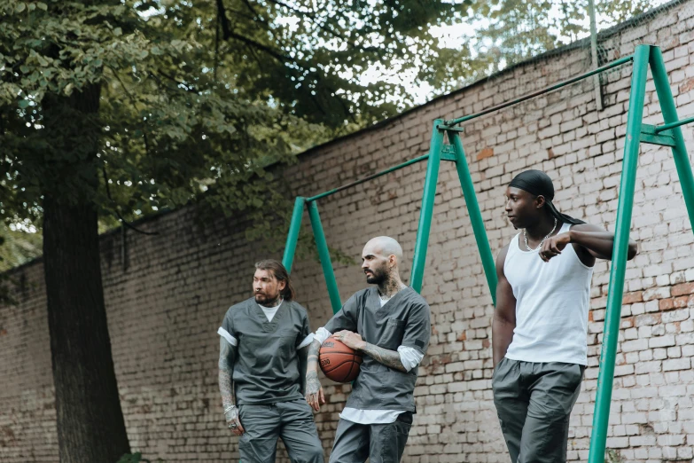 a group of men in matching clothing play with a basketball