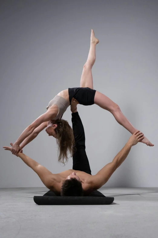 two people doing yoga on the floor with their hands in the air