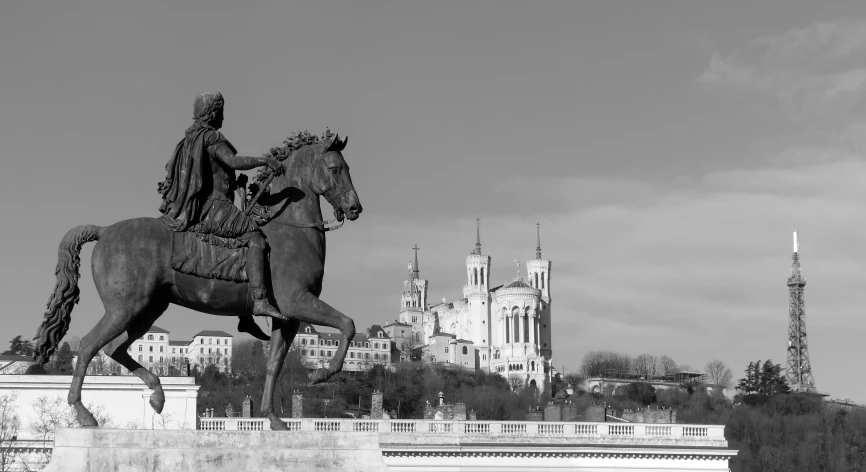 a statue of a man on horseback standing in front of a castle