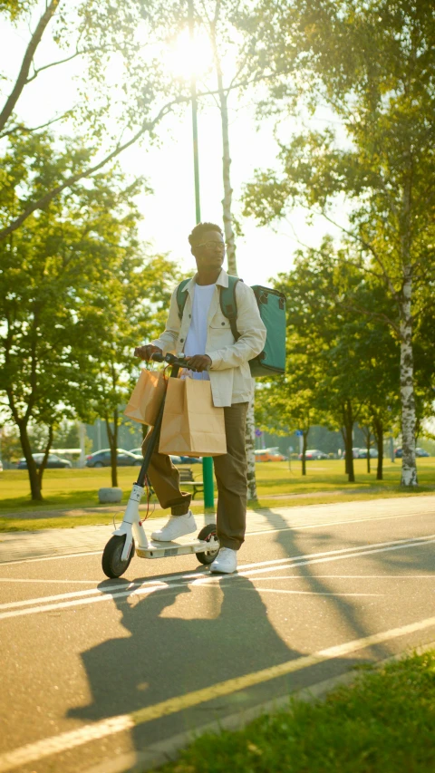 a person on a scooter holding shopping bags and a light pole