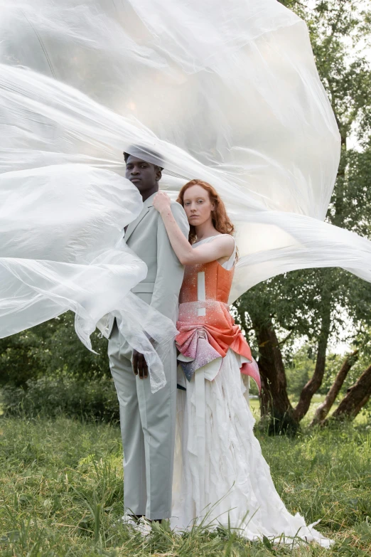 an african american couple dressed in white posing for a po