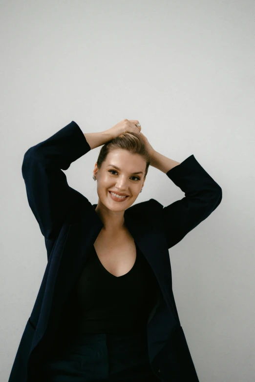 a woman standing with her hands in her hair