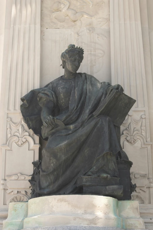 the statue sits outside a huge building with columns