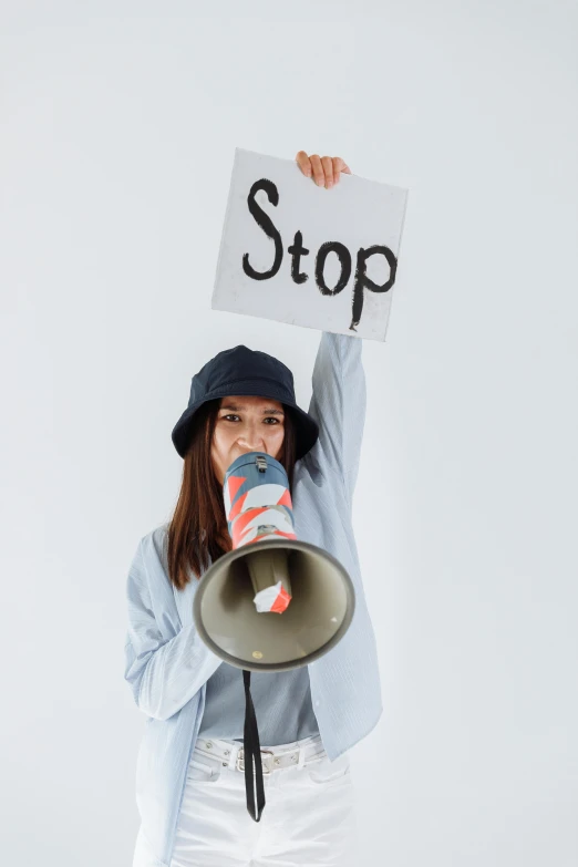 a woman holding a sign with a large bell