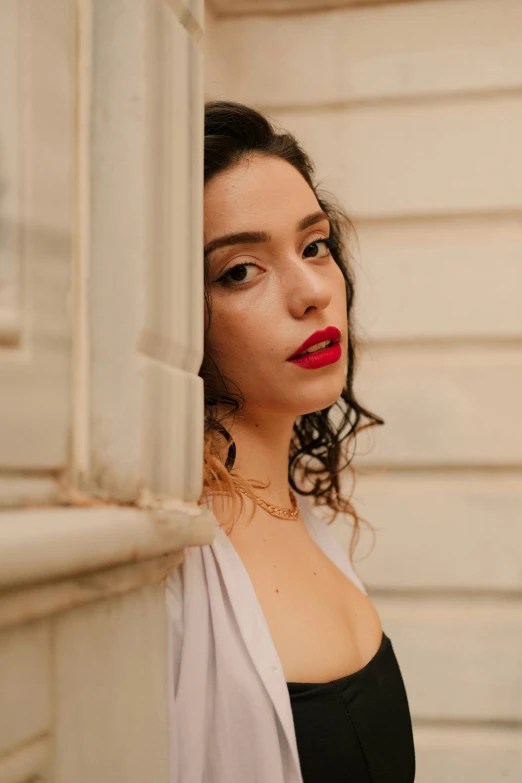 a woman leans on the wall with her hand on her face