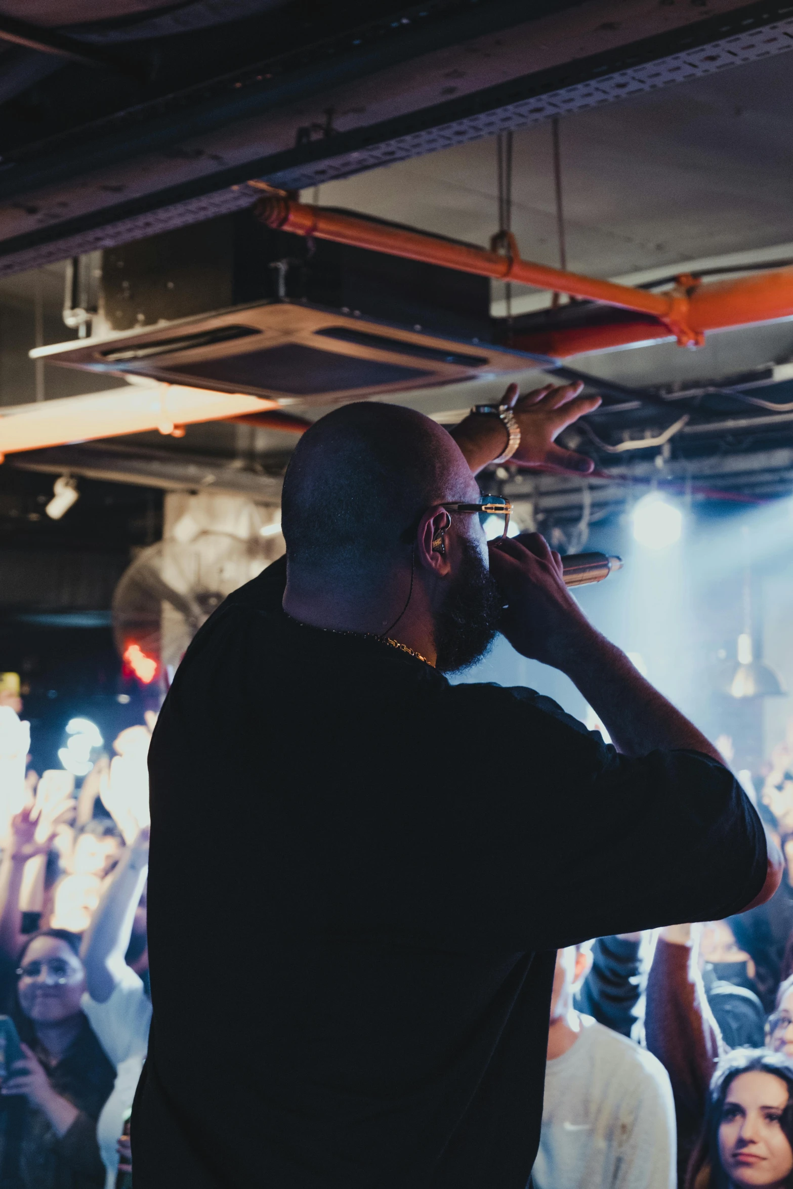 a person that is singing and people sitting in the background