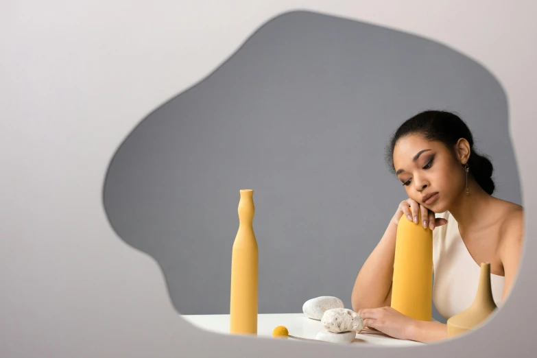 a girl sits at a table with some yellow objects