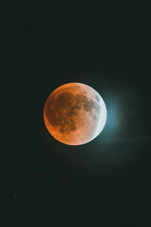 a red moon on a black sky in the dark