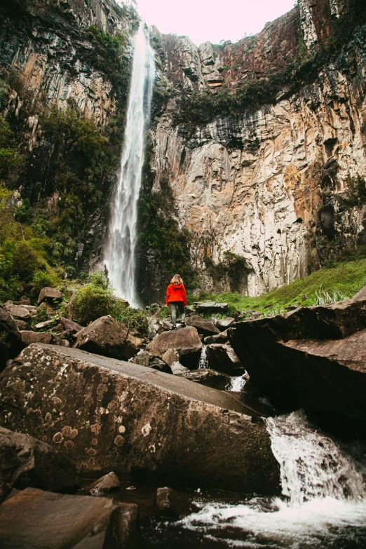 there is a waterfall and a red umbrella near by