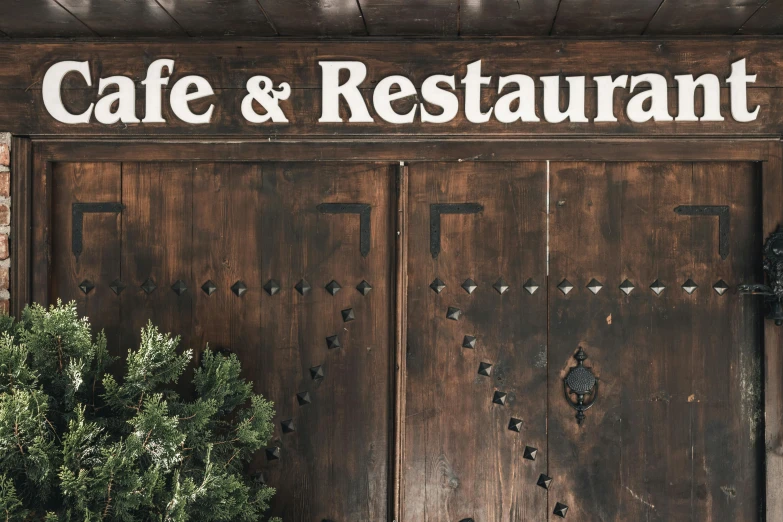 a restaurant with a wood door that says cafe and restaurant