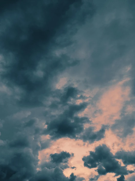 the airplane is flying in the sky during a cloudy day