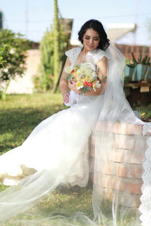 a woman sitting on top of a brick wall