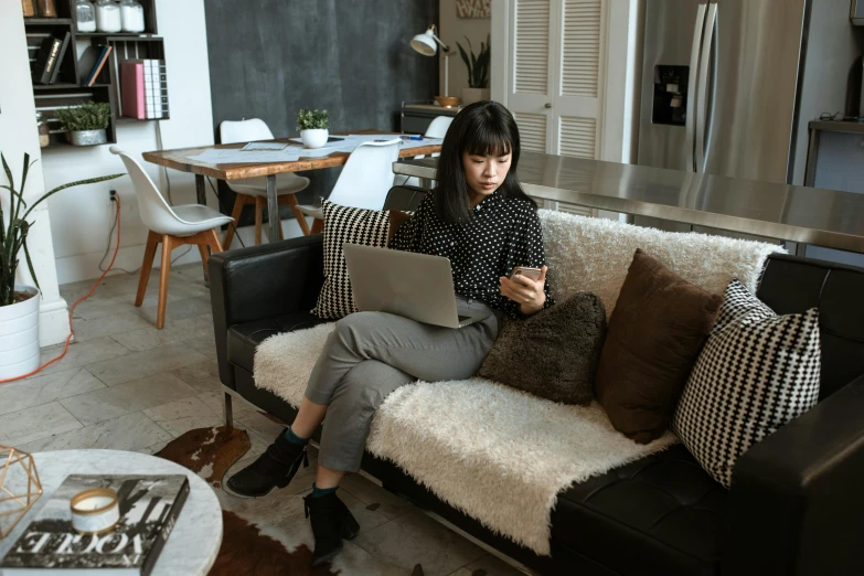 woman sitting on the couch using her laptop