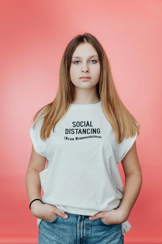 a beautiful young woman wearing jeans and a shirt with social distancing on it