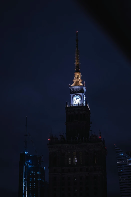 the spire of the clock tower is lit up with a clear light