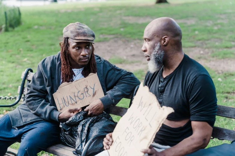 a couple of men sitting on top of a bench