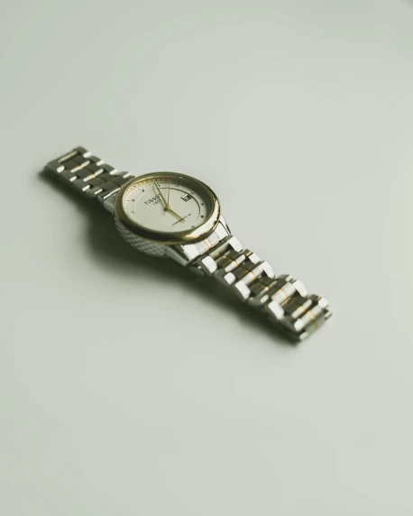 a small wrist watch on top of a watch strap