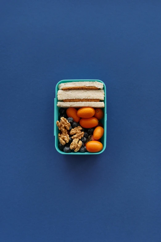 the plastic container with lunches sits on a blue surface