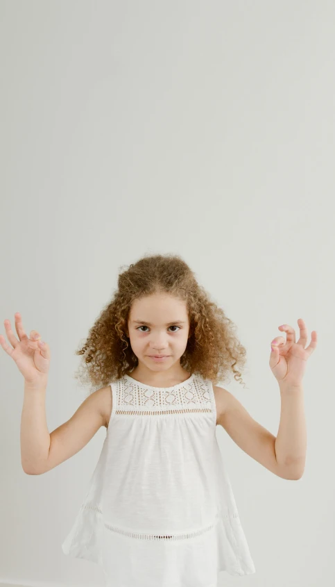 a little girl that is making a hand gesture
