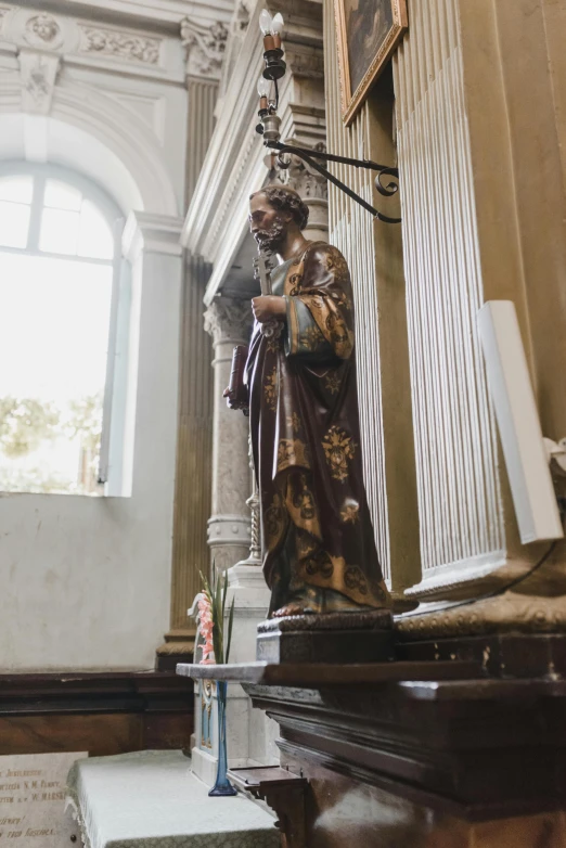 a statue of jesus next to an old church pulpit