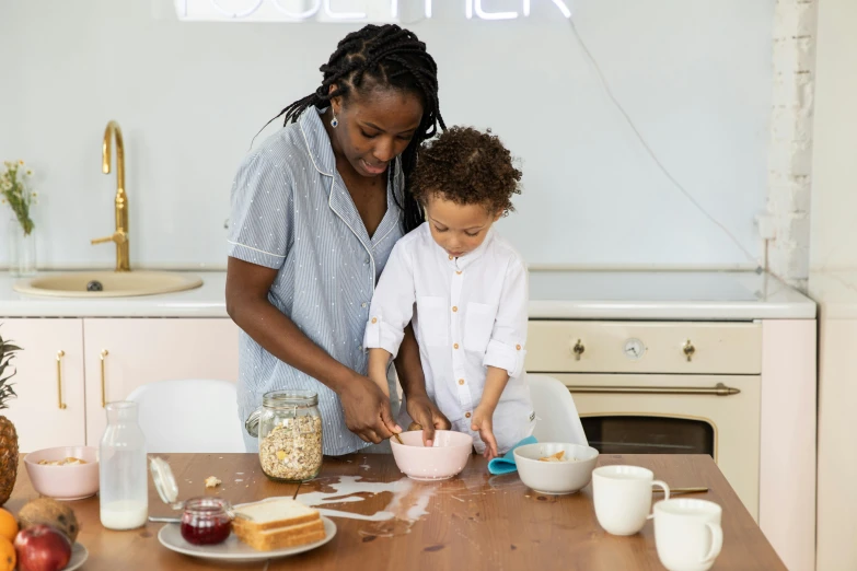 a woman is helping a child with a bowl