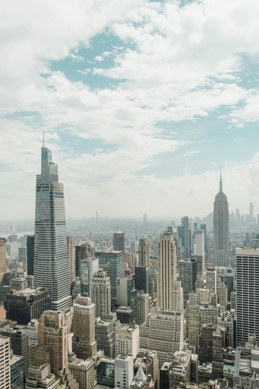 a cityscape with skyscrs, a clock tower and a cloudy sky