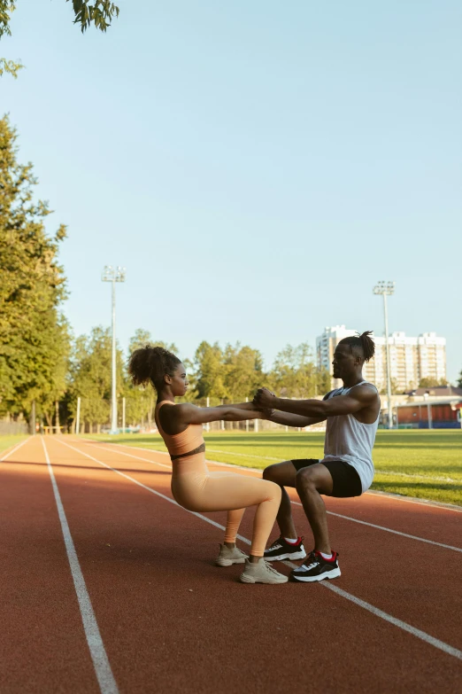 two people on a running track holding their hands