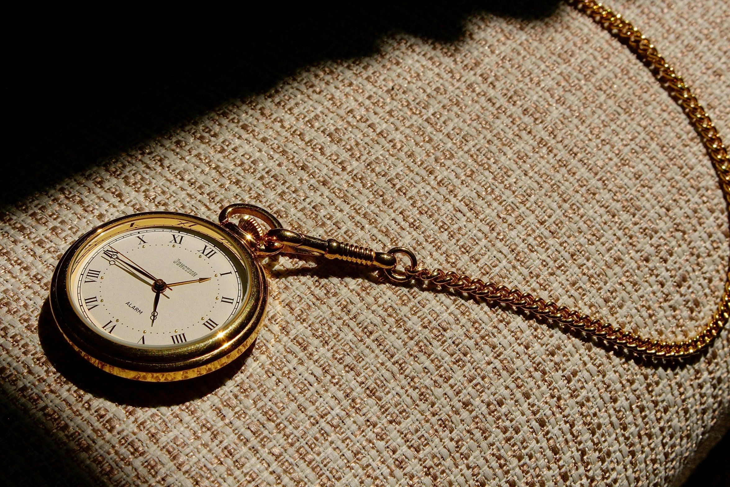 an antique pocket watch is sitting on a piece of fabric