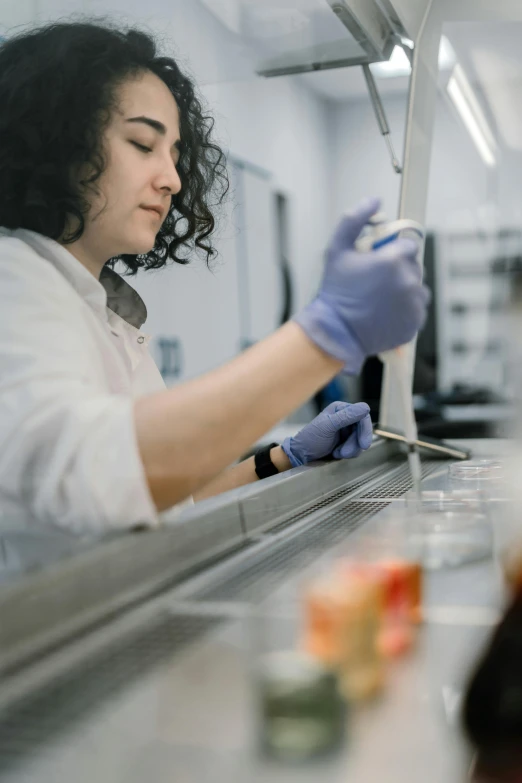 a female factory worker wearing gloves and making canned food