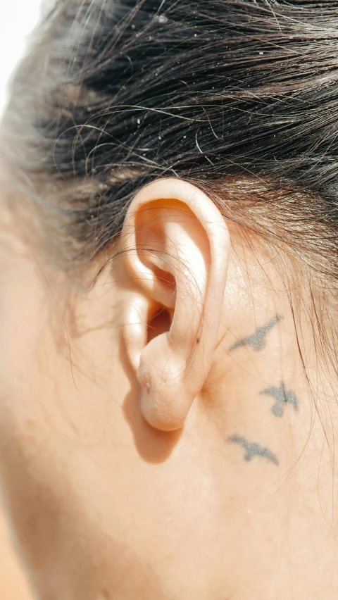 a woman with a tattoo behind her ear