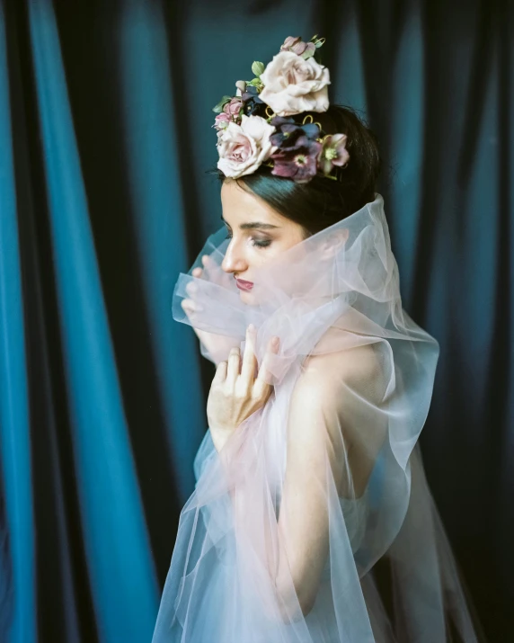 a woman in a veil with pink roses on her head