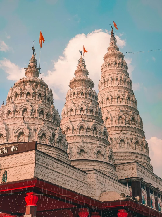 the spires of two very large buildings sit above a city street