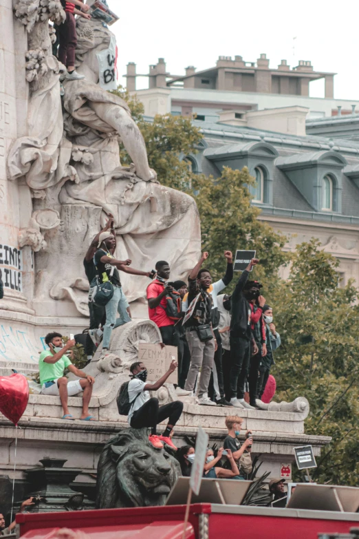 the group of people are sitting and walking on the sculpture