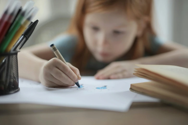 a little girl is drawing with a pencil