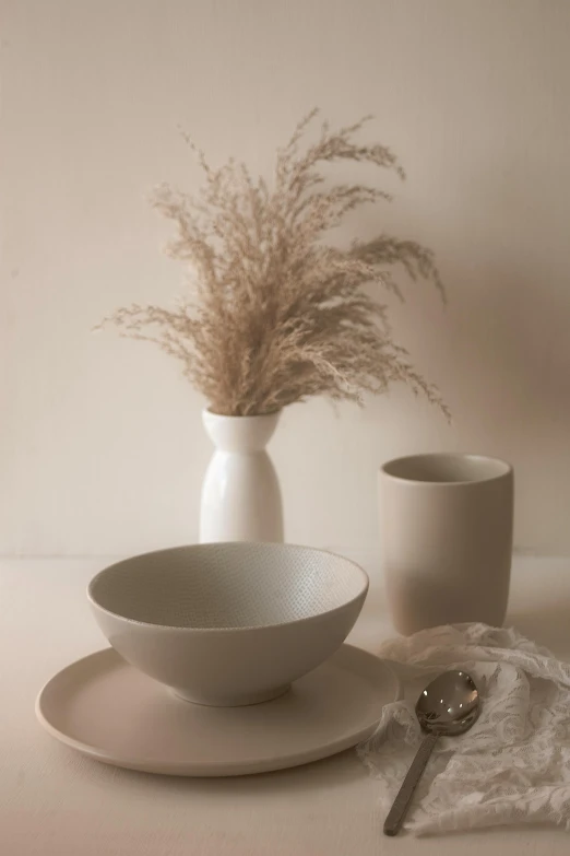 a small table that includes two plates and a vase of flowers