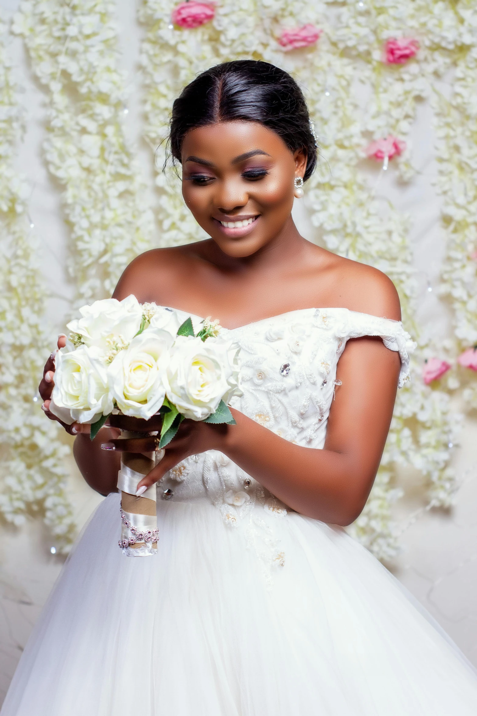 a woman in a white dress holds a bouquet of roses