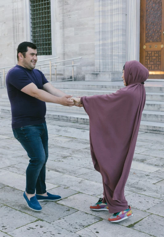 a man holding a large cloth with another person in the background