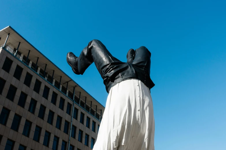 an art piece depicting a woman in black with her legs folded down