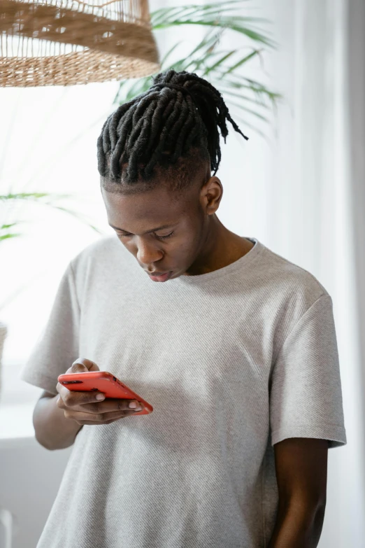 a woman stands and looks down at her cellphone