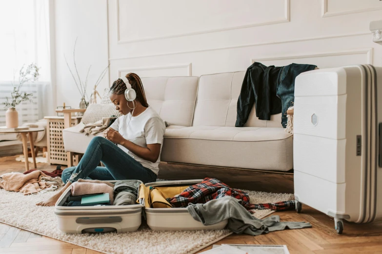 a woman sitting on the floor in an open suitcase