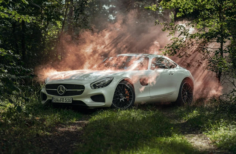 a white mercedes benz in front of some dirt