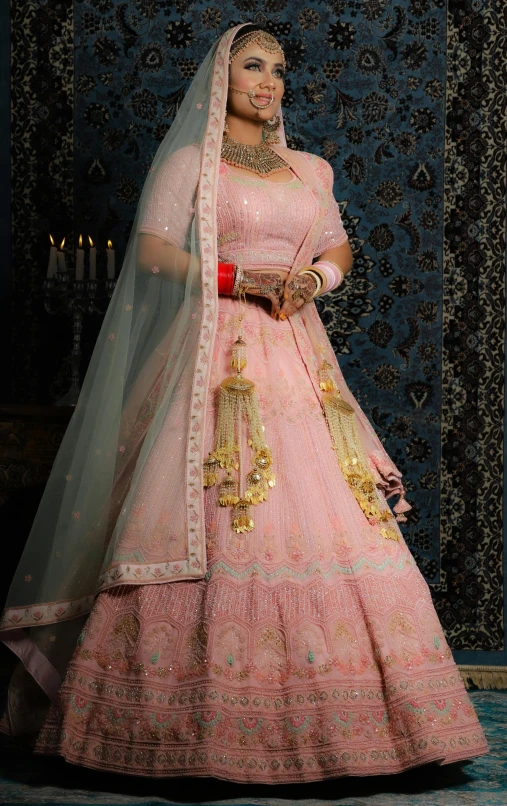 an indian woman in pink and gold bridal gown