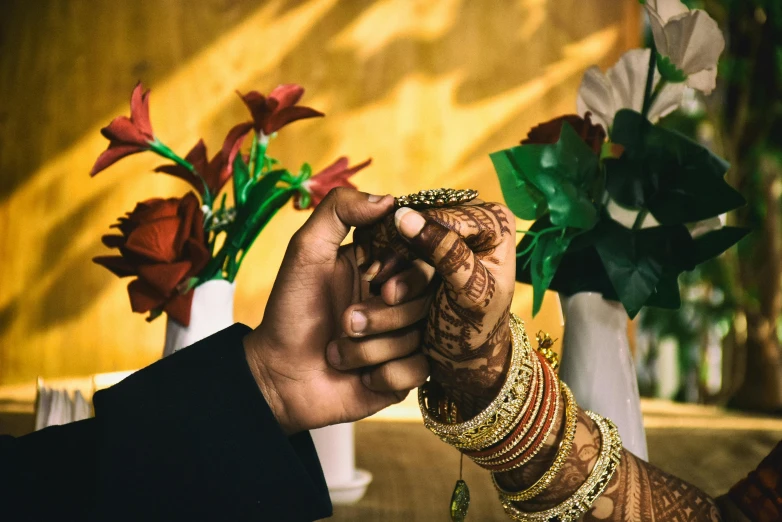 two people putting ring on each other's hand